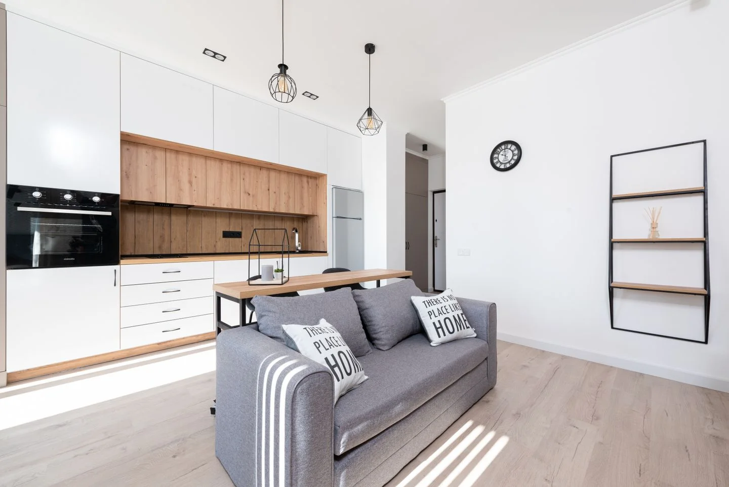 Living space with an open kitchen and several pieces of furniture.