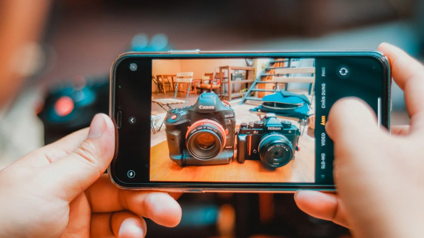 Phone being used to photograph cameras.