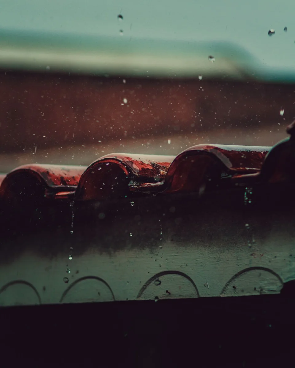 Raindrops falling onto a tiled roof.