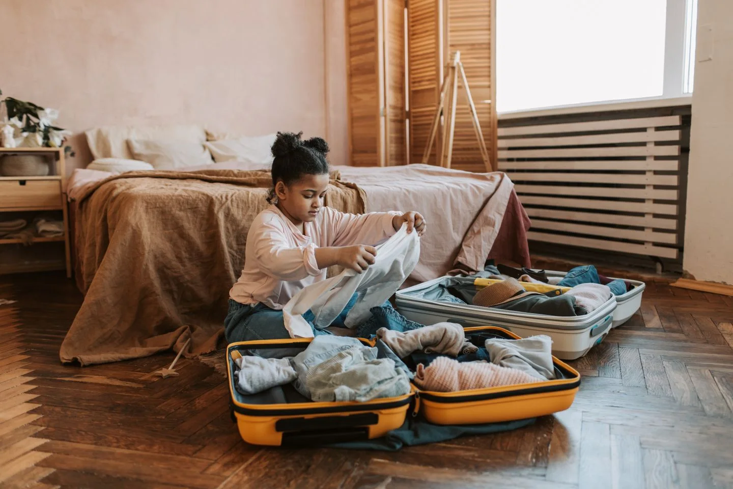 A girl packing clothing into a suitcase
