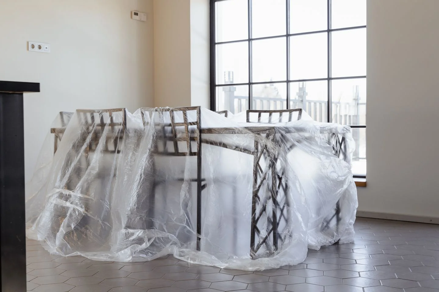 Dining table and chairs under protective plastic