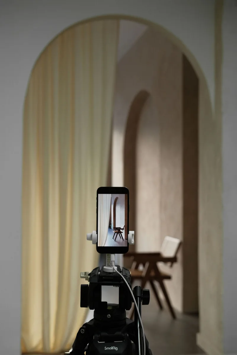 A smartphone on a tripod records an interior
