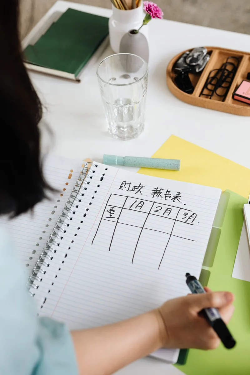 Hand writing a list in a notebook